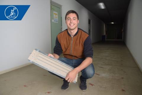 Miguel Poveda, con un prototipo de antena, en un pasillo de la Escuela de Telecomunicación donde ha realizado ensayos para su tesis.